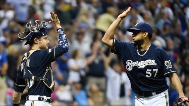 FILE - In this Sept. 27, 2014, file photo,?Milwaukee Brewers catcher Jonathan Lucroy, left, and pitcher Francisco Rodriguez celebrate after the Brewers beat the Chicago Cubs 2-1 in Milwaukee. In addition to the normal aches and pains of spring training, the Brewers are dealing with a rash of pink eye that has broken out in the clubhouse. Catcher Jonathan Lucroy and pitching coach Rick Kranitz were the latest victims Thursday, March 12, 2015. Hoping to avoid spreading the annoying and highly contagious malady, the Brewers are staying away from the usual high-fives in the dugout. (AP Photo/Benny Sieu, File)