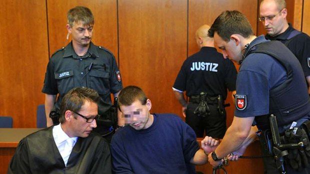 Guilty ... a police officer takes off the handcuffs of defendant Jan O, whose face has been blurred in accordance with German law.