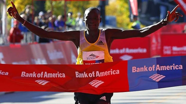Dennis Kimetto of Kenya celebrates as he crosses the finish line to win the Chicago Marathon with a new course record.