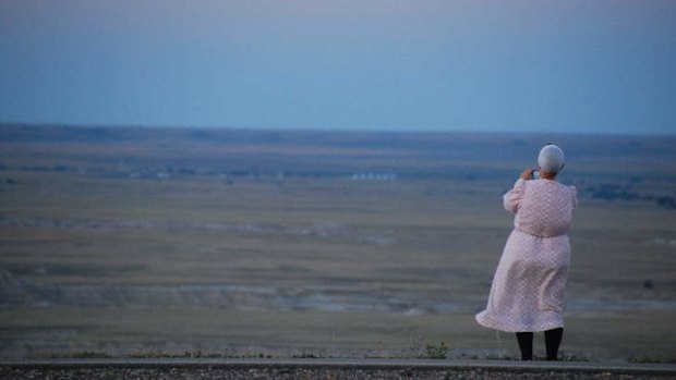 A woman takes a snapshot of the vista.