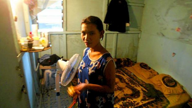 A captive sex worker in the room where she lives and works on the Indonesian island of Batam.