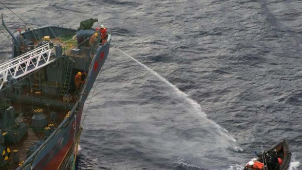 A water canon is sprayed from a Japanese whaling ship towards a small Sea Shepherd boat, about 480 km north of Mawson Peninsula off Antarctica's coast.