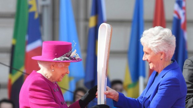 Queen Elizabeth II, left, holds the relay baton with Louise Martin, the President of the Commonwealth Games Federation, at the launch of The Queen's Baton Relay for the XXI Commonwealth Games being held in the Gold Coast.