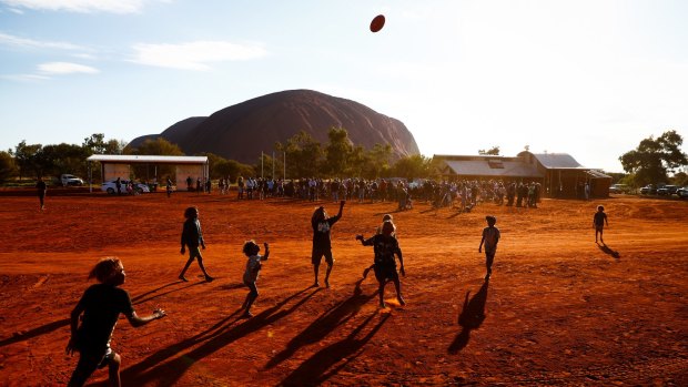 Children play footy during the closing ceremony in the Mutitjulu community of the First Nations National Convention. 