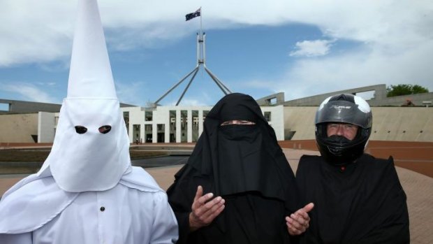 Three men cover their faces to protest the wearing of the burqa in public places.