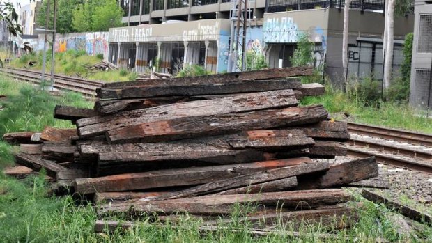A large pile of timber sleepers lies next to the railway tracks near Toorak Road, Toorak.