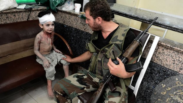 Victims rising &#8230; a Free Syrian Army fighter comforts a boy who was wounded when a shell hit his home in Aleppo.