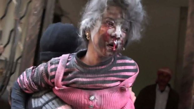 Casualty: An image grab taken from a video uploaded on YouTube shows a man carrying an injured girl in the rebel-held city of Rastan, central Syria.