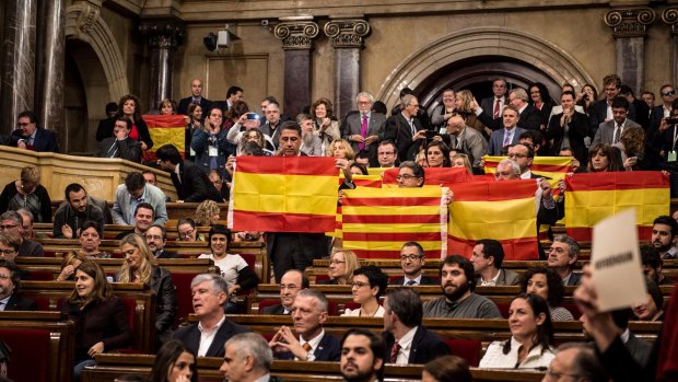 Partido Popular de Catalunya (Popular Party of Catalonia) members of Catalan parliament brandish Spanish flags at the end of the parliamentary session on Monday in Barcelona. 