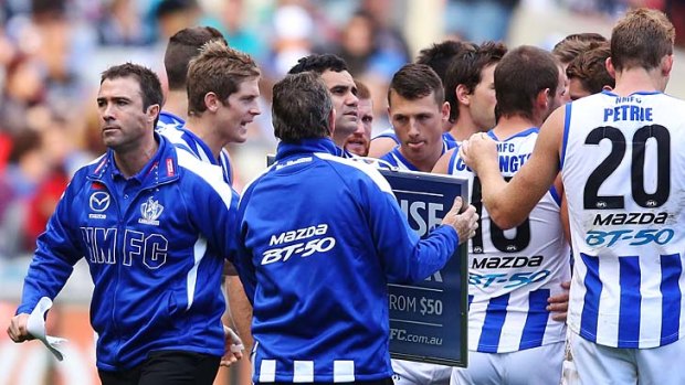 Kangaroos coach Brad Scott leaves the three-quarter-time huddle during the match against Collingwood.