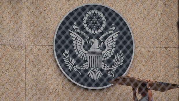 A worker carries cardboard inside the compound of the United States embassy in Havana, Cuba.