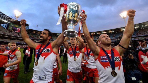 Tripping the light: Adam Goodes and Jarrad McVeigh hoist aloft the cup of dreams.