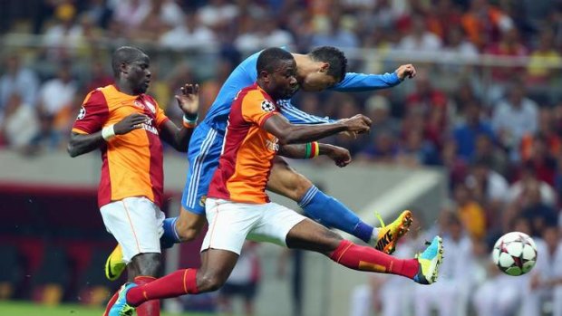 Real Madrid's Cristiano Ronaldo, centre, vies for the ball with Aurelien Chedjou.