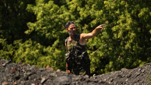 Pro-Russian rebel Yuri near where searchers look for remains and possessions near the MH17 crash site.