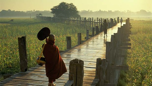 A Buddhist monk crosses U Bein Bridge in Burma.