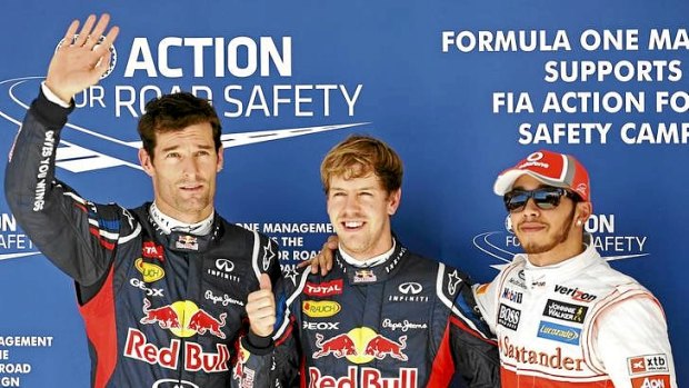Red Bull Formula One driver Sebastian Vettel of Germany (centre) gives a thumbs-up next to teammate Mark Webber (left) of Australia and McLaren Formula One driver Lewis Hamilton of Great Britain.