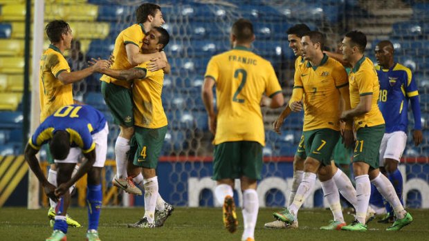 Tim Cahill celebrates with team mates after scoring his second goal against Ecuador in their friendly in London.