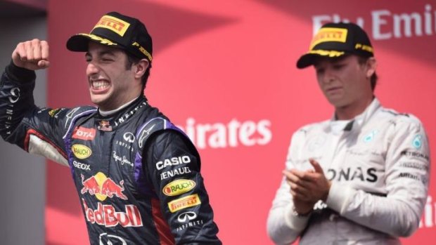 Daniel Ricciardo celebrates on the podium after his maiden victory in formula one.