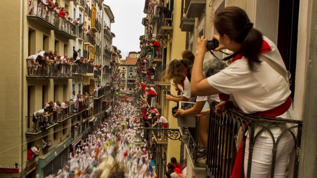 Revellers and bulls during the running of the bulls, at the San Fermin festival, in Pamplona, Spain.