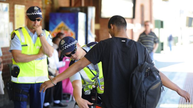 Police search a man at Footscray railway station.