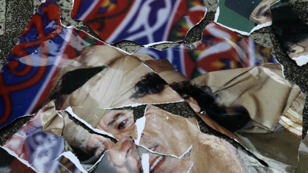 A torn portrait of Muammar Gaddafi outside the Libyan embassy in the Philippines illustrates the extent of his downfall.