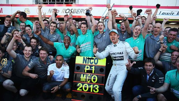 Nico Rosberg (centre), Lewis Hamilton and the Mercedes team celebrate.