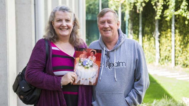 Julia and Barry Rollings at the Legislative Assembly on Thursday with a photo of their daughter's wedding in the US.