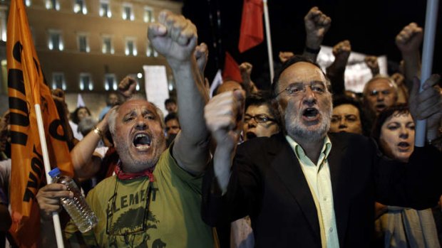 Lawmakers and supporters of the left wing opposition party Syriza who  exited the parliament building to support anti-austerity  protesters, shout slogans during a protest in front of the Greek parliament in Athens. (AP Photo/Kostas Tsironis)