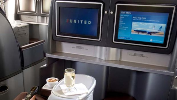 United Airlines business-class: comfortable with a large shelf under screen for storage.