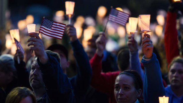 Mourners hold candles and U.S. flags during a vigil for Martin Richard, one of three killed in the Boston Marathon bombings.