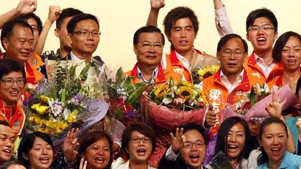 Strong showing &#8230; pro-China Democratic Alliance party chairman Tam Yiu-chung celebrates with supporters.