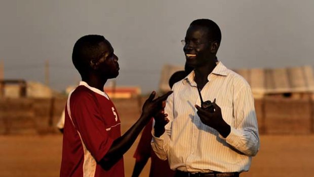 Sudanese Australian Mayath Wak (right) enjoys a moment with his friend from the opposing Abyei town team after the game on their new field.