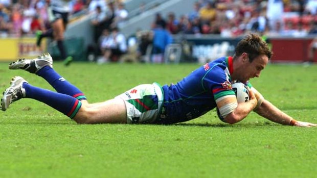 James Maloney of the Warriors crosses for a try against the Broncos.