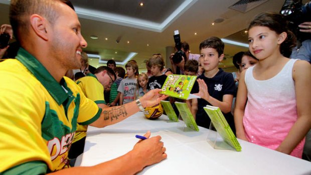 Retired Broncos player Scott Prince and Logan deputy principal David Hartley sign books for young fans Ned, 7, and sister Milly, 9, Naouri, from Annerley, at the launch of "Deadly D and Justice Jones - Making the Team"