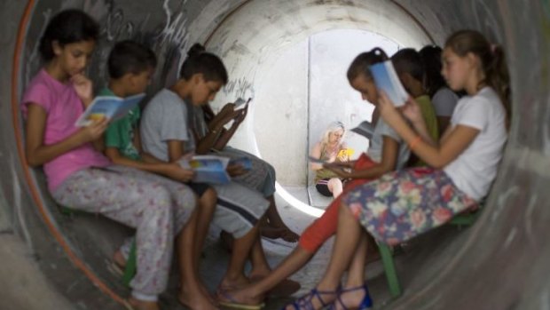 Israeli children sit in a street shelter in Nitzan, after rocket warning sirens went off. 