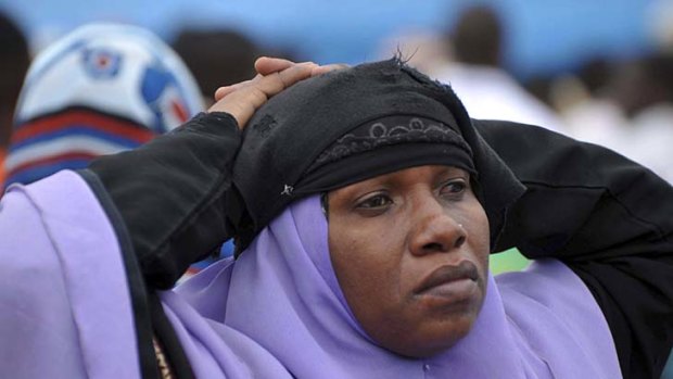 A woman waits for her loved ones in Zanzibar after an overcrowded ship sank off mainland Tanzania.