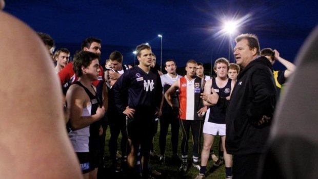 Grant Thomas (right), seen here with members of the Warrnambool Football Netball Club,  has taken aim at coaches locked in a "defence paranoia".