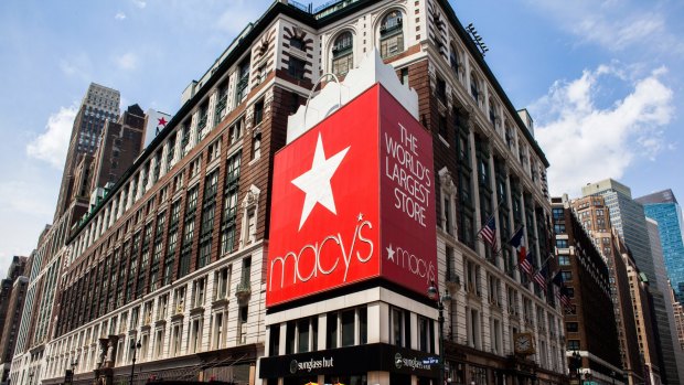 Pedestrians and shoppers pass in front of a Macy's store in New York. The retail giant has said it plans to close 100 stores. 
