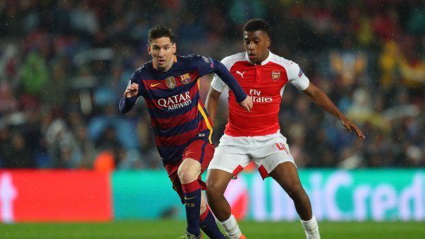 Lionel Messi of Barcelona and Alex Iwobi of Arsenal compete for the ball during the UEFA Champions League, which will be available direct of Foxtel.