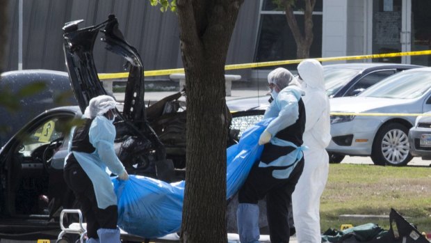 The bodies of gunmen Elton Simpson and Nadir Soofi are removed from behind a car during an investigation by the FBI and local police in Garland, Texas.