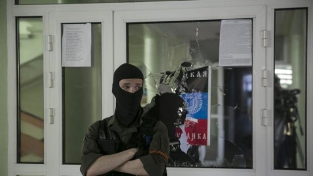 A pro-Russian masked man stands watch inside the Mariupol town hall in east Ukraine.