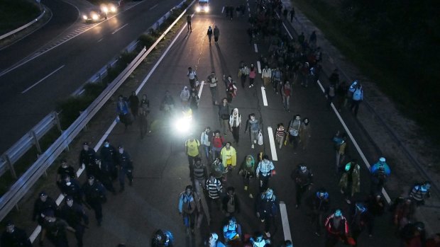 Migrants walk in the dark on the M5 motorway, 169 kilometres south-east of  Budapest, Hungary.