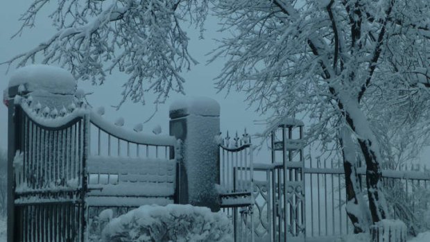 Snow-covered cemetery gates.