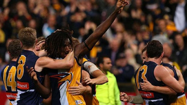 Nic  Naitanui is mobbed by jubilant teammates after kicking a goal after the siren to beat North Melbourne.