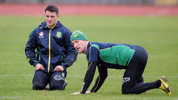 Kangaroos veterans Cooper Cronk and Brent Tate limber up during training at Manchester.