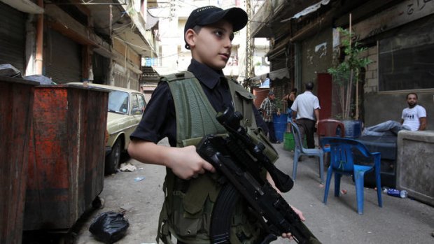 A 10-year-old Sunni boy poses with a gun in Tripoli.