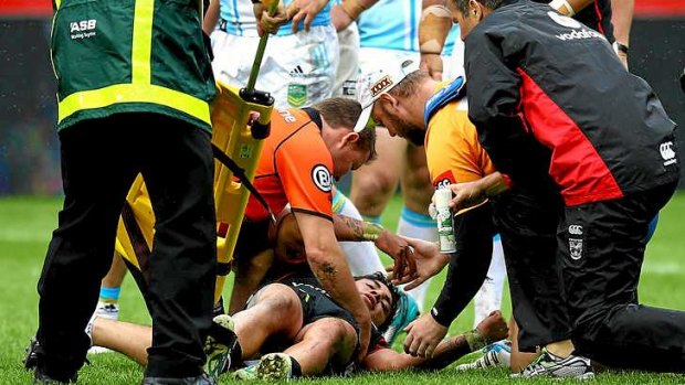 Kevin Locke of the Warriors is treated by medical staff after injuring his back.