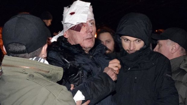 Bloodied: Ukrainian opposition leader Yuri Lutsenko is taken from the scene of protests in Kiev on Saturday morning. 