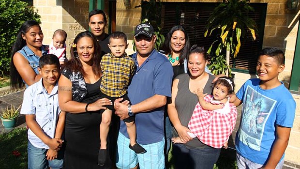 Happy outcome: Lellah and Ali Woulf with eight of their children and their grandchild at their new home in Hurstville.