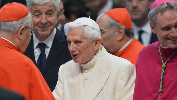 Not pressured: Pope emeritus Benedict XVI (centre) is greeted by a cardinal in St Peter's Basilica.